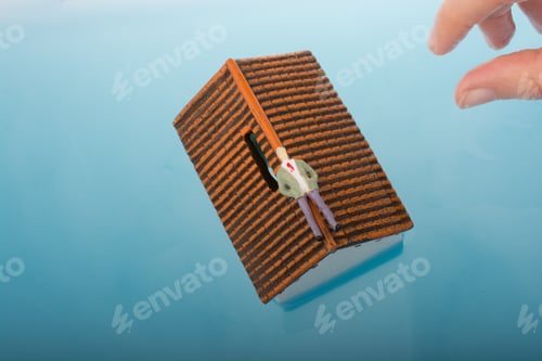Preview: Hand Holding A Man Figurines In Water By The Side Of A Little Model House