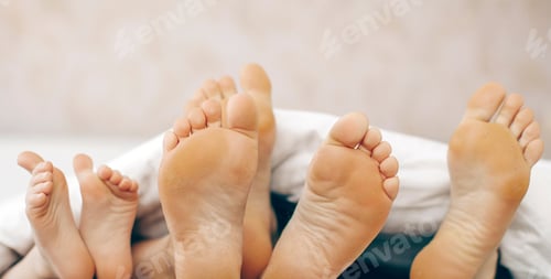 Preview: Mother, Father And Two Children Lie On Bed