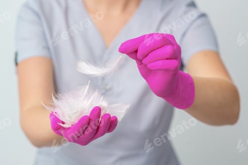 Preview: Feathers In Hands Of Woman Beautician Doctor. Concept Of Health Softness Skin And Body Care.