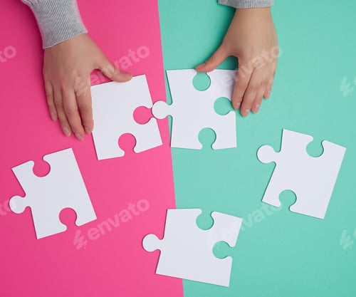 Preview: Empty Paper White Pieces Of Puzzles In Female Hands, Puzzle Connected, Colorful Background, Top View