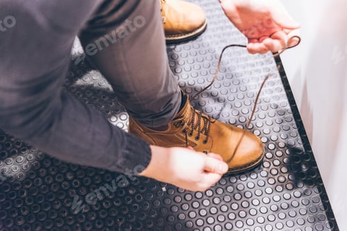 Preview: Man Tie Shoelaces On Shoes. Fashion Boots