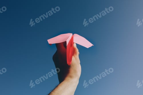 Preview: Guy Is Holding A Pink Handmade Plane. Freedom Concept Photo With A Blue Sky On Background. Travel
