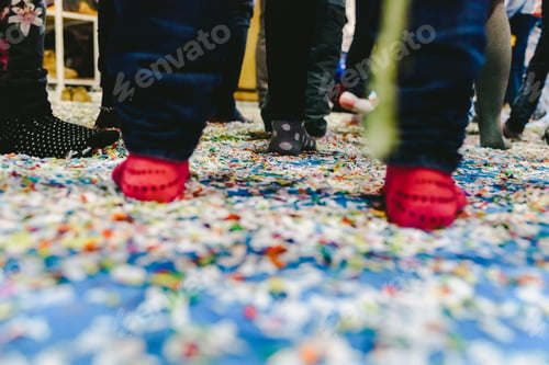Preview: People In Socks Stepping On A Floor Full Of Confetti During A Party.
