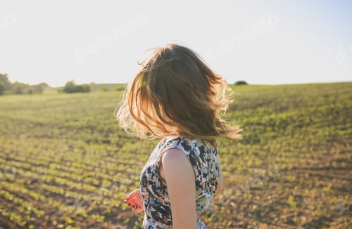 Preview: Girl In Rustic Dress Is Standing In The Field With Seed Beds. Beautiful Woman Is Turning Her Head