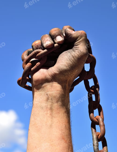 Preview: Man'S Hand Wrapped In An Iron Rusty Chain Lifted Up Against A Blue Sky