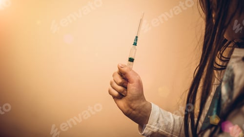 Preview: Little Girl Holding A Syringe With A Liquid Inside. Concept Fight Against Virus Covid-19 Corona