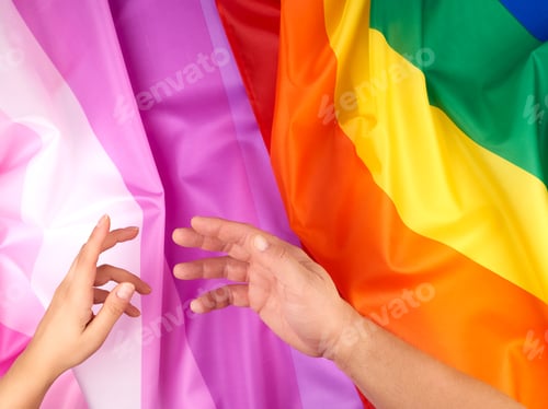 Preview: Female And Male Hand Outstretched Against The Background Of Flags Of Lgbt Communities, Concept