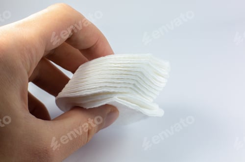 Preview: Man Holding White Cotton Sponges On White Background. Close Up Photo. Beauty, Medicine And