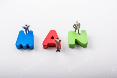 Preview: Tiny Figurine Of Men Beside Colorful Wooden Letters Say Man