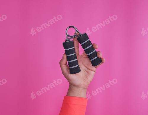 Preview: Black Espander In Female Hand On Pink Background, Copy Space
