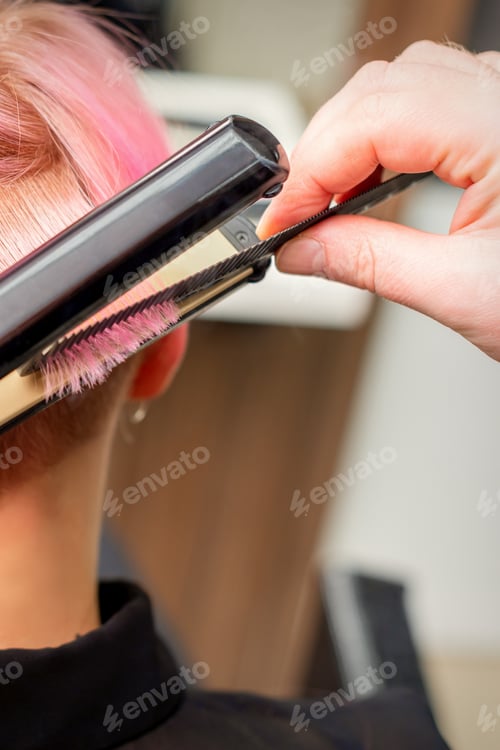 Preview: Close Up Of The Hairdresser Straightening The Short Pink Hair Of A Female Client With A Hair
