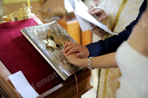 Preview: Bride And Groom Holding Hands On Bible