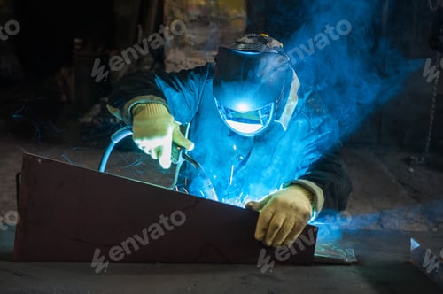Preview: Worker Welding Metal With Sparks At Factory