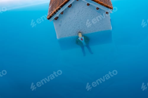 Preview: Man Figurines In Water By The Side Of A Little Model House