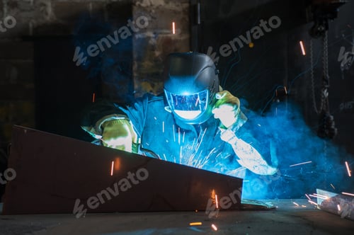 Preview: Worker Welding Metal With Sparks At Factory
