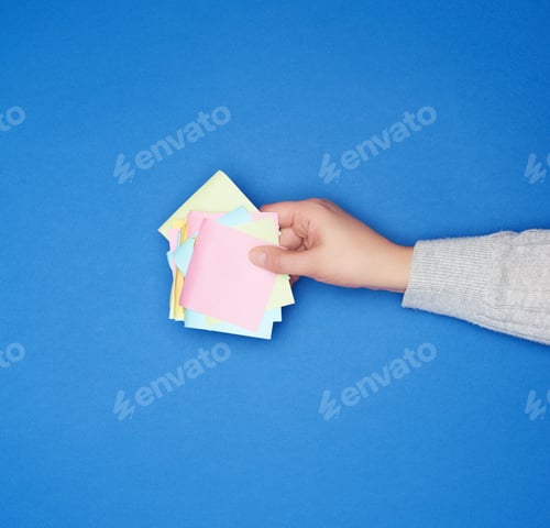 Preview: Female Hand And Many Empty Paper Multi-Colored Stickers On A Blue Background, Top View