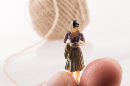 Preview: Woman Figure Beside A Linen Spool Of Thread On A White Background