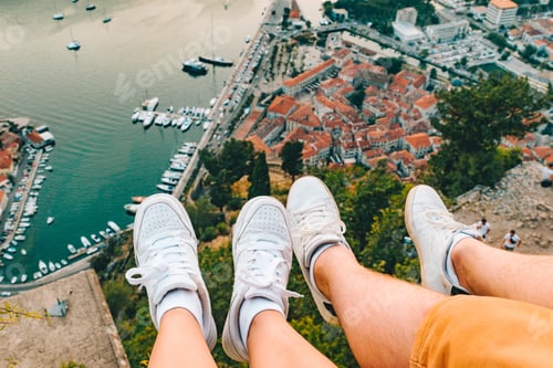 Preview: Couple Legs At Hill With Beautiful View Of Kotor City On Background. Summer Vacation