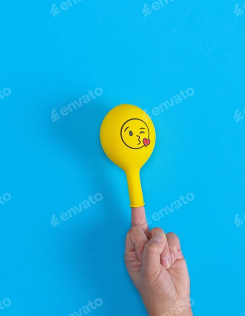 Preview: Yellow Inflated Ball Dressed On The Middle Finger Of A Human Hand, Blue Background