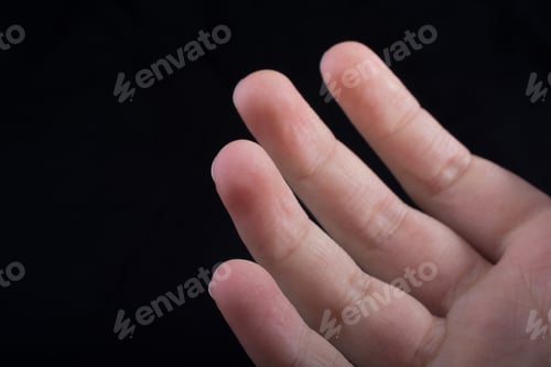 Preview: Four Fingers Of A Child Hand Partly Seen In Black Background