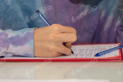 Preview: Close-Up Of Student Hand Writing In Notepad