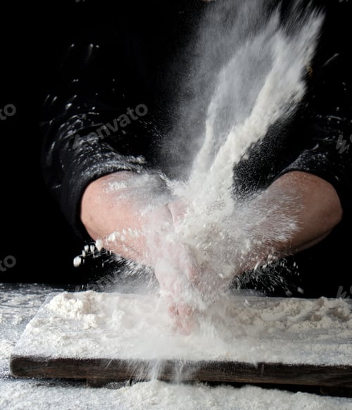 Preview: Chef In Black Uniform Sprinkles White Wheat Flour In Different Directions, Product Scatters Dust