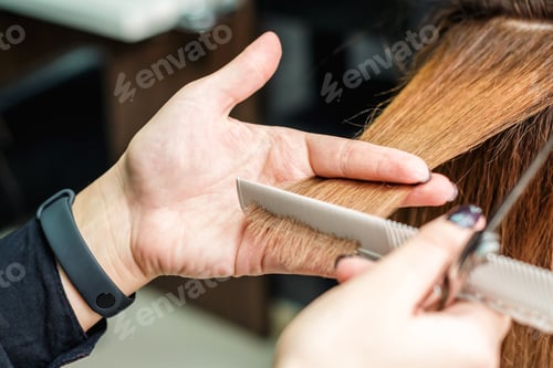 Preview: Female Hairdresser Is Holding In Hand Between Fingers A Red Hair Is Cutting Woman Hair Close Up.
