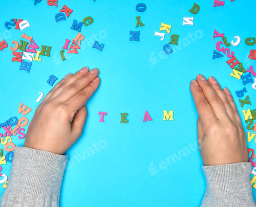 Preview: Female Hand And Multicolored Wooden Letters Of The English Alphabet On A Blue Background