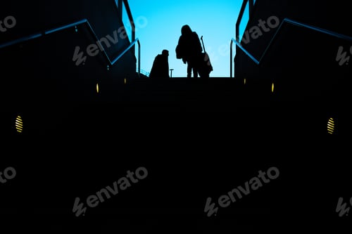 Preview: Silhouette Of Two Passengers With Their Suitcases Trolley Climbing A Ladder