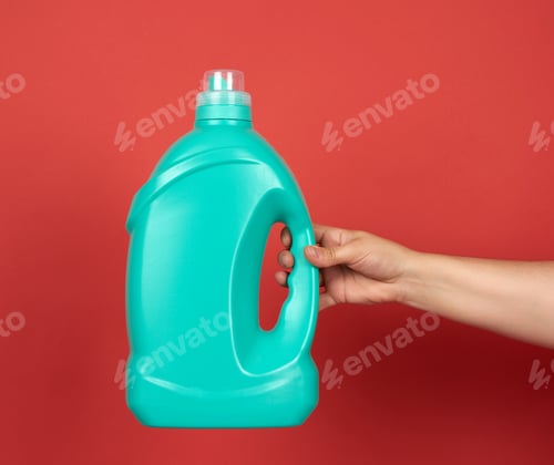Preview: Hand Holds A Green Big Bottle With Liquid Detergent For Washing Clothes On A Red Background