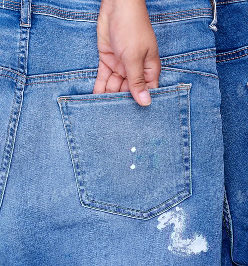 Preview: Female Hand Is Stuck In The Back Pocket Of Blue Jeans, Close Up, Full Frame