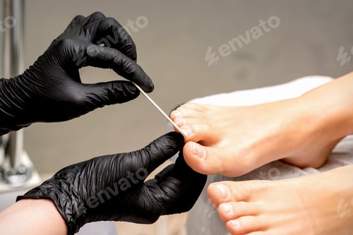 Preview: Pedicure Master'S Hands In Protective Rubber Gloves File Female Toenails With A Nail File In A