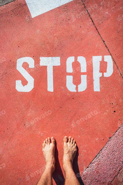 Preview: An Illegal Immigrant Stands Barefoot At A Stop Sign On The Ground.