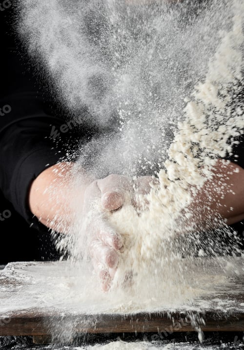 Preview: Chef In Black Uniform Sprinkles White Wheat Flour In Different Directions, Product Scatters Dust