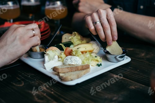 Preview: Hands Taking Snacks From The Plate On Wooden Table In Pub