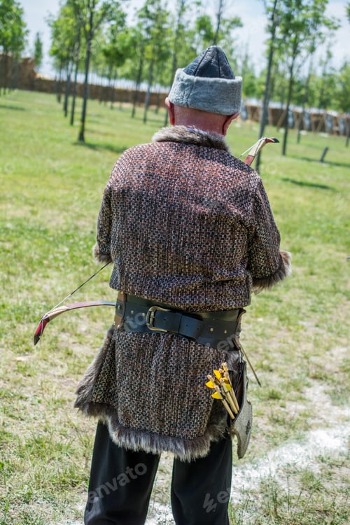 Preview: Archer With Bow In Traditional Clothes Shooting An Arrow