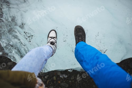 Preview: Couple Holding Feet In Boots On Ice Block