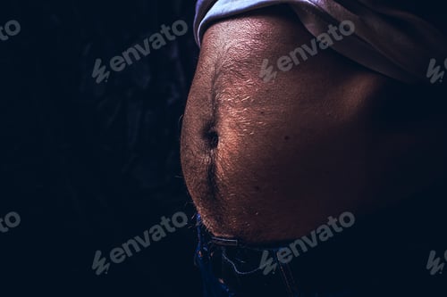 Preview: Close Up Of Perfect Male Body With A Belly Or Paunch Isolated On Black Background With Copy Space.