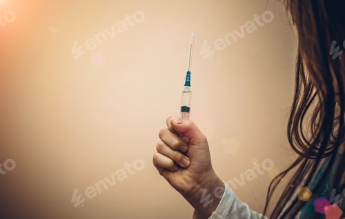 Preview: Little Girl Holding A Syringe With A Liquid Inside. Concept Fight Against Virus Covid-19 Corona