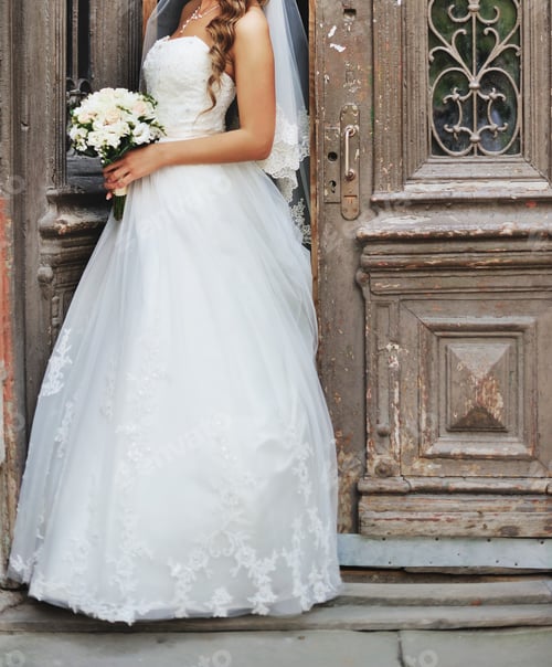 Preview: Bride in White Dress Holding a Bouquet