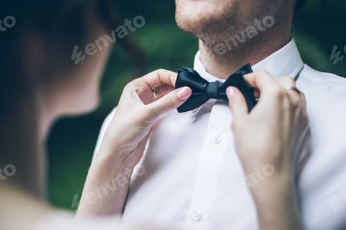 Preview: Woman Check Mans Bow Tie In Park