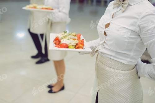 Preview: Waiter Holding Plate With Meat And Red Pepper At Restaurant