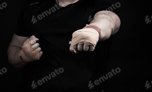Preview: Adult Man In A Black Uniform And Muscular Arms Stands In A Sports Stance, Holds A Sports Elastic