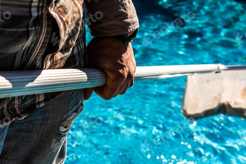Preview: Maintenance Man Using A Pool Net Leaf Skimmer Rake In Summer To Leave Ready For Bathing His Pool.