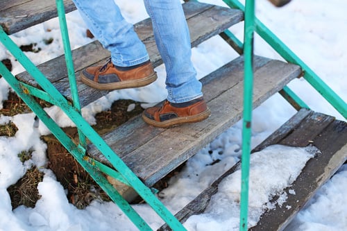 Preview: Male Feet In Jeans And Leather Boots Walking On A Wooden Stairway