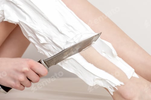 Preview: Hand Of Woman Is Shaving Her Leg By Knife With Shaving Foam, Close-Up. Depilation Or Epilation