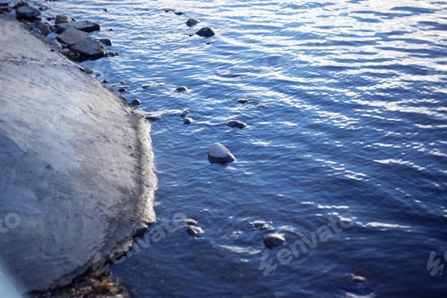 Preview: Blue Water Ripples Near Concrete Shore Background
