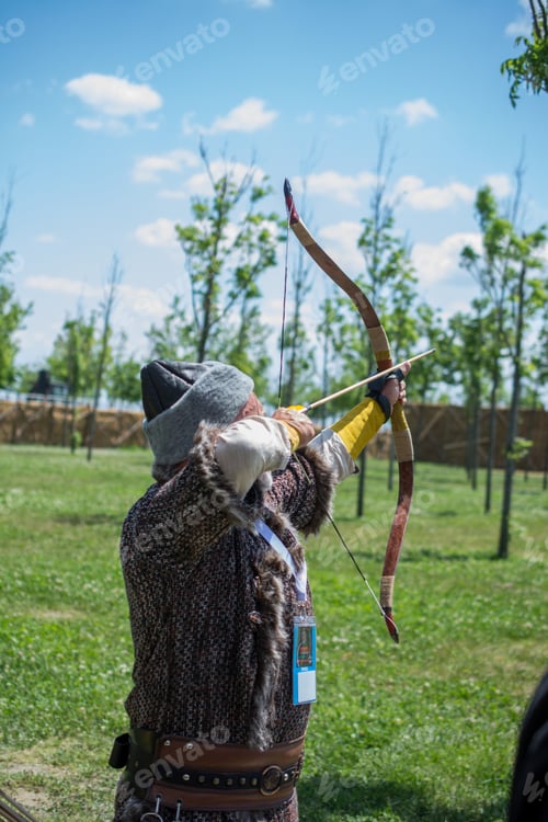 Preview: Archer With Bow In Traditional Clothes Shooting An Arrow