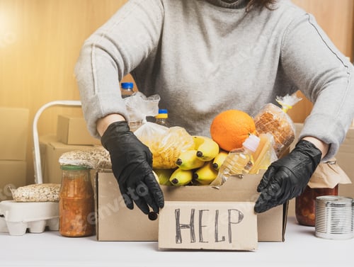 Preview: Woman In A Gray Sweater Is Packing Food In A Cardboard Box, The Concept Of Assistance And