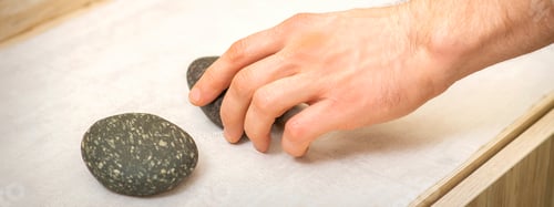 Preview: Hand Of Massage Therapist Taking Massage Stones From The Table Before Massage Procedures
